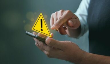 Personne tapant sur un smartphone avec un panneau d'avertissement jaune