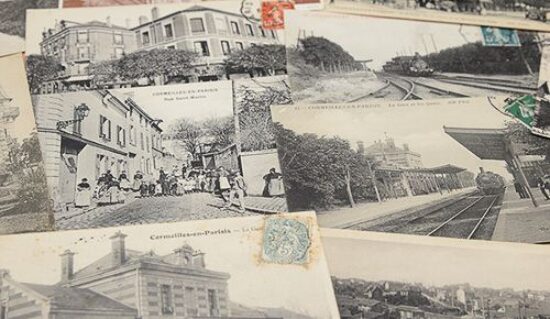 Plusieurs anciennes cartes postales de Cormeilles-en-Parisis posées sur une table
